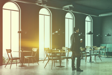 African American man in a loft cafe interior, side