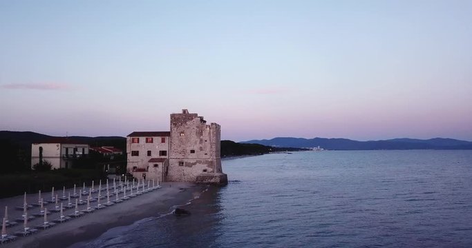 Torre Mozza, Piombino, Toscana, Italy &mdash; 16 June 2018. Aerial view on the sea, beach and ancient fortress at sunset