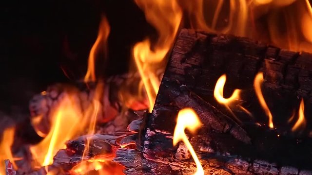 Close up view of bright orange flame and burning wood in fireplace. Slow motion hd video footage.
