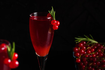 Glass of redcurrant wine drink juice decorated with rosemary berries