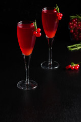 Two glasses redcurrant wine drink juice decorated with rosemary berries