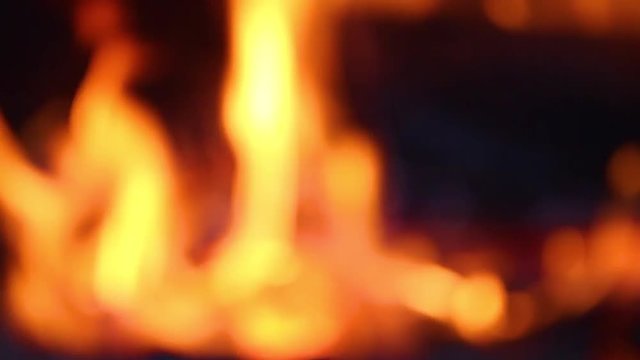 Close up view of blurry bright orange flame and burning wood in fireplace. Out of focus slow motion hd video footage.
