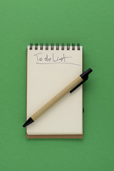 Pen and Notepad on the green background. To Do List