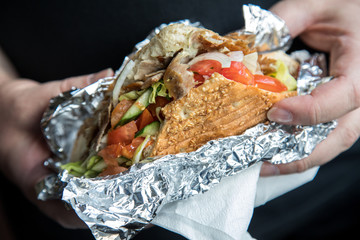 Mann isst Döner im Fladenbrot mit Salat und Kalb Fleisch in Aluminiumfolie  © Christin Klose