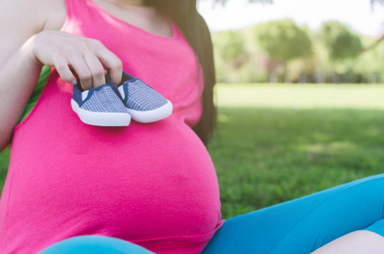 Pregant woman with baby shoes