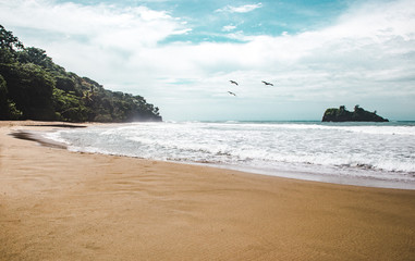 View of the small rocky island off the beach of Playa Cocles, near Puerto Viejo, on the Caribbean coast of Costa Rica