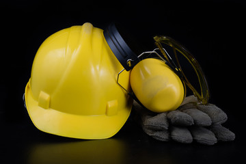 Helmet and workwear on a black working table. Accessories for construction workers.