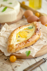 KHACHAPURI or hachapuri filled pie with egg and cheese. Open pie with egg and cheese Flatbread with egg and cheese.