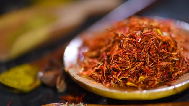 Saffron. Various Indian spices on a dark stone table. Spice and herbs on black background. Dolly shot. Slow motion. 3840X2160 4K UHD video footage