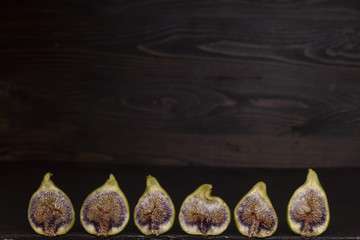 aufgeschnittenen Feigenfrüchte in einer Reihe mit Holzhintergrund