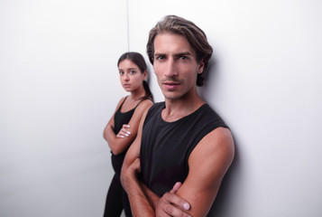 Naklejka premium serious young couple standing near the wall