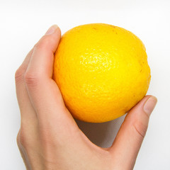 The woman's hand is holding an orange