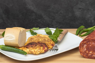 Plato con tortilla de chorizo y pimientos picantes