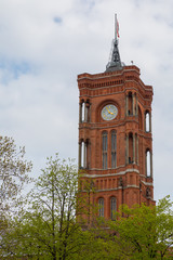 Tall tower above trees in front of cloudy sky