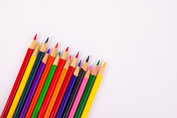 Angeled assorted multi colored map pencils on solid white background