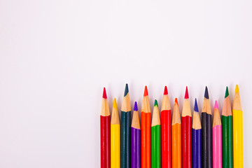 Assorted colors map coloring pencils framed lower right on solid white background