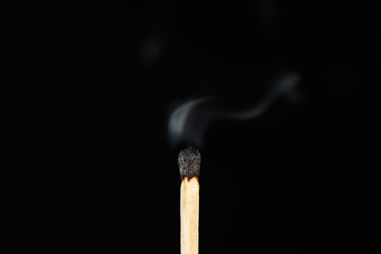 Match with the burned head and heavily steaming up on a black background closeup
