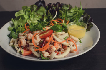 Salad with seafood, arranged with vegetable salad.