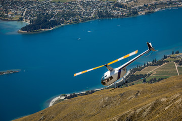Helicopter returning to Wanaka having ferried telecom engineers to the top of Roy's Peak to repair the signal tower - obrazy, fototapety, plakaty