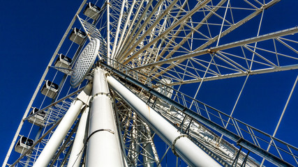 Amusement park ferries wheel. White metal structure.