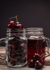 Glass of cherry juice on wooden table