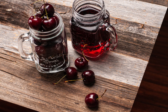 Glass of cherry juice on wooden table