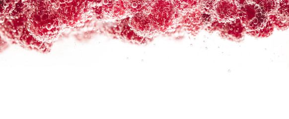 Fresh raspberries in water wiht air bubbles.