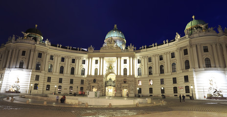 View of Hofburg illuminated at dusk, the imperial palace of the Habsburgs, from Michaelerplatz Vienna, Austria