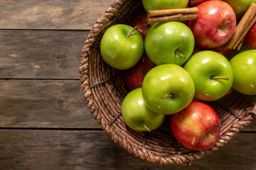 Apples red and green on rustic wooden table in basket 