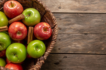 Apples red and green on rustic wooden table in basket 