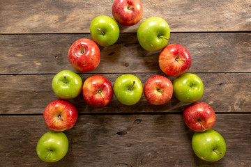 Apples red and green on rustic wooden table in basket 