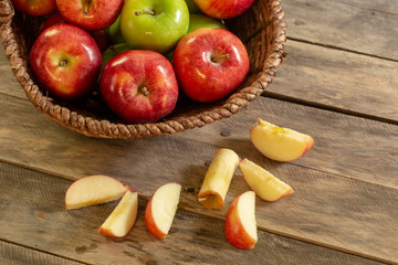 Apples red and green on rustic wooden table in basket 