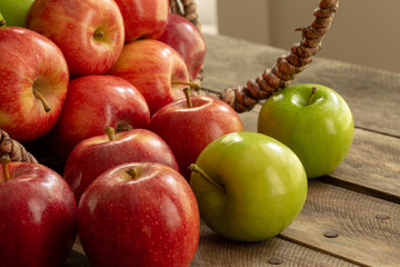 Apples red and green on rustic wooden table in basket 