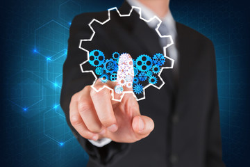 Businessman give a thumbs up for touching the glowing gear elements as business, innovation, Mechanism and idea concept.