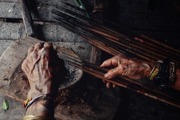 Muara Siberut, Mentawai Islands / Indonesia - Aug 15 2017: Tribal elder Toikot poisoning arrowheads for hunting at his jungle home