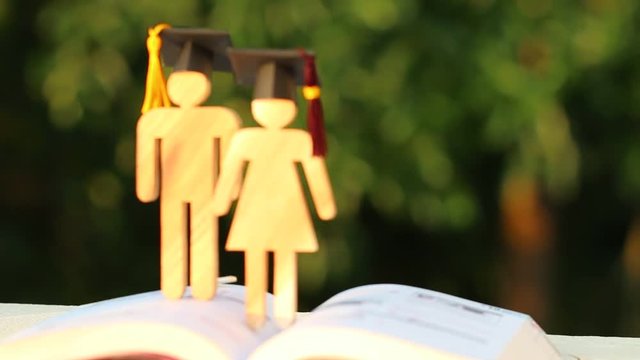 Back to School Concept, Two People Sign wood with Graduation celebrating cap on open textbook show alternative studying. Graduate or Education knowledge learning study abroad international Ideas.