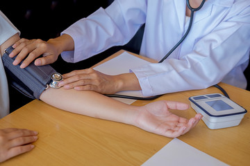 Obraz premium Patient listening intently to a male doctor explaining patient symptoms or asking a question as they discuss paperwork together in a consultation