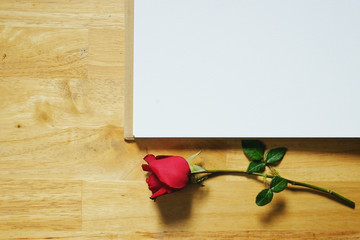 Red rose and notebook, blank book on wooden background.Top view. Valentine's day holiday concept. Copy space