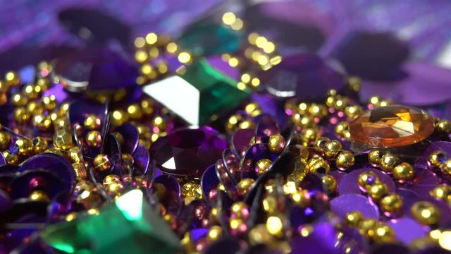 Extreme closeup of finger pressing a purple rhinestone into a puddle of hot glue.