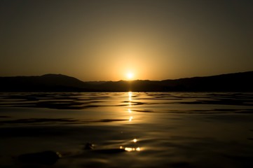 Fototapeta na wymiar Lake with light waves in sunset