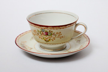 An isolated porcelain cup in a saucer
