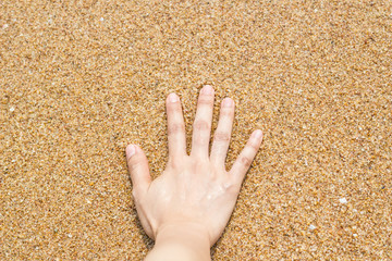 Female hand on the sand at the beach