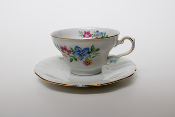 An isolated porcelain cup in a saucer