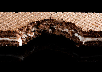 vanilla flavor wafer blocks with a big bite on black background close up
