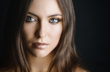 Obraz premium Close-up portrait of young woman with golden makeup.