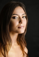 Obraz premium Close-up portrait of young woman with golden makeup.