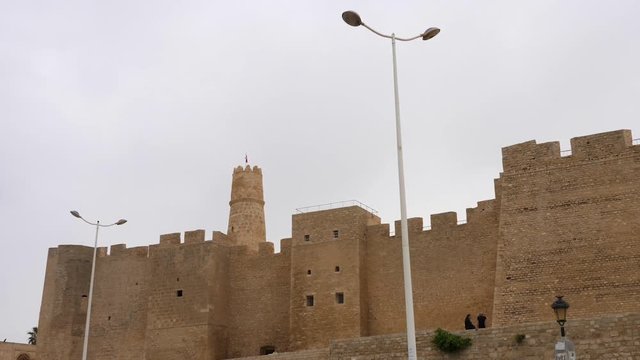 Ribat of Monastir and lantern on street at cloudy day in Tunisia, close up