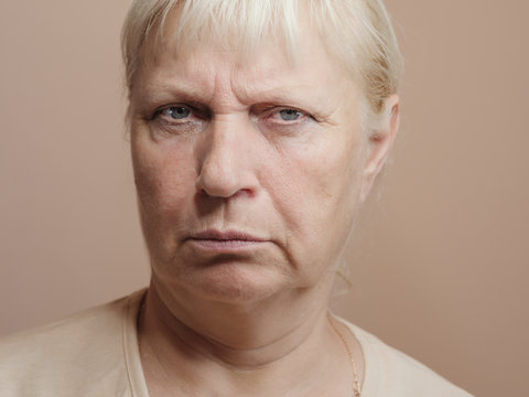 Middle aged woman portrait on light background.