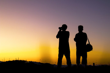 Fototapeta na wymiar Silhouette of a photographer taking photo with sunset.