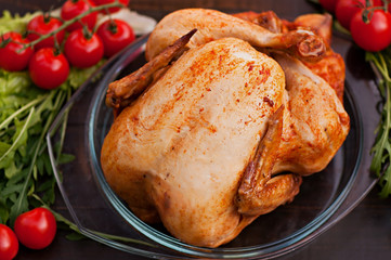 Baked chicken, on an old wooden background. Natural food cooked on the grill.